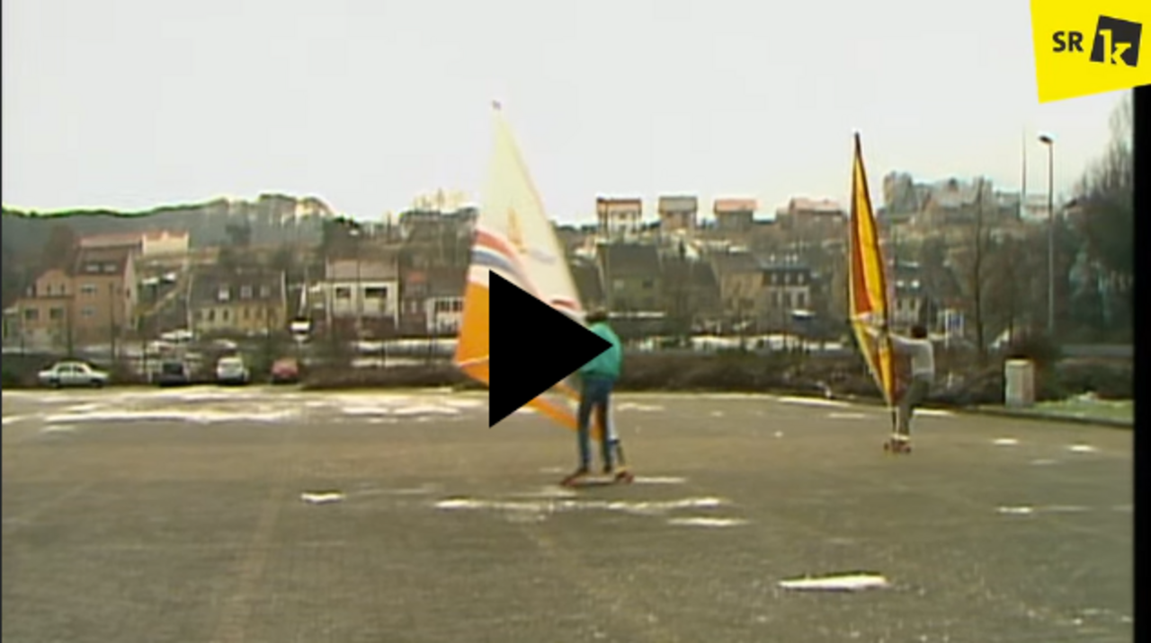 Zwei Strandsurfer auf einem Parkplatz im Winter